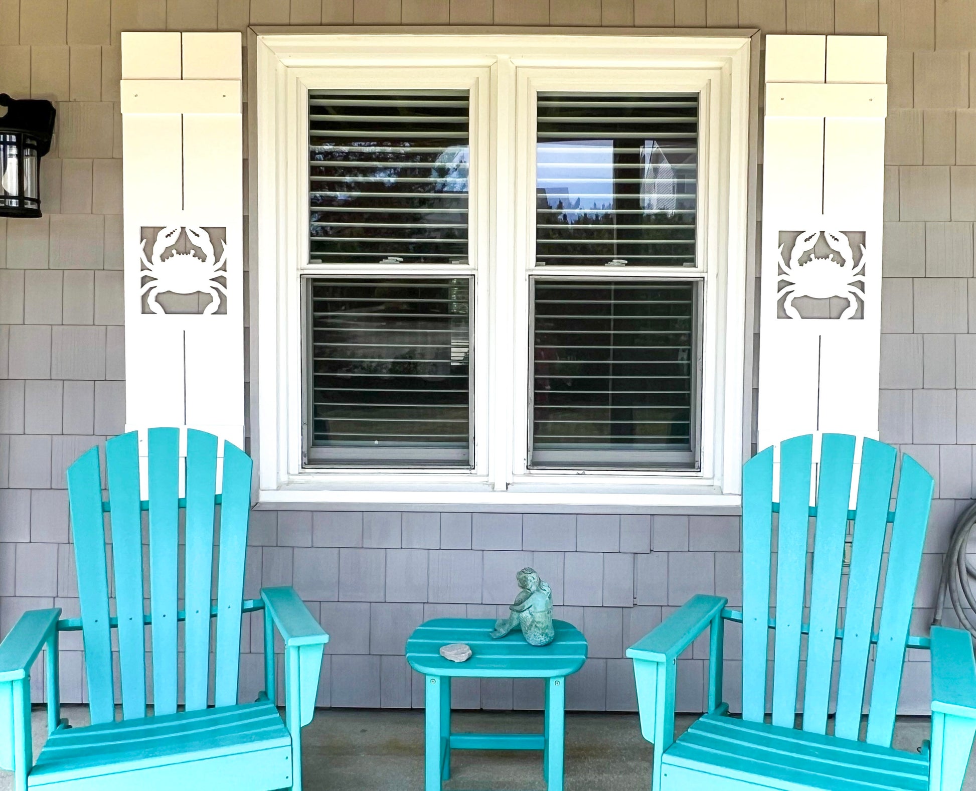 Exterior board and batten style coastal window shutters with crab cutout. Weatherproof PVC beach house shutters for outdoor decor.